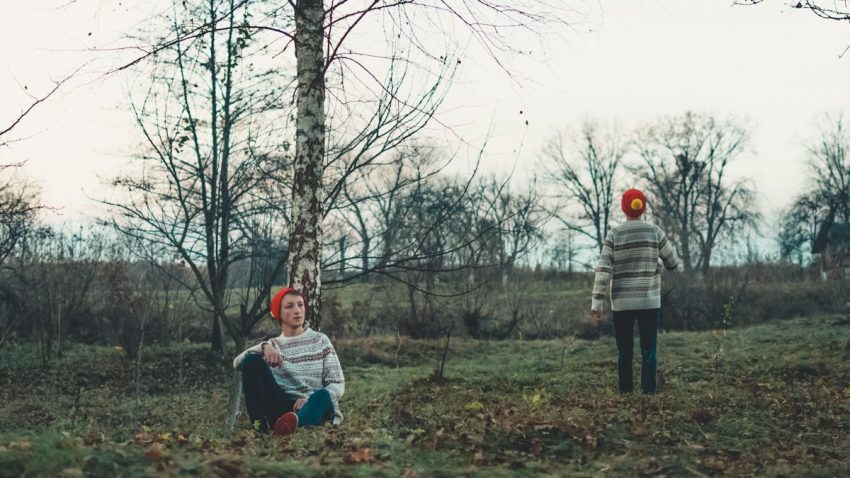 man sitting beside tree